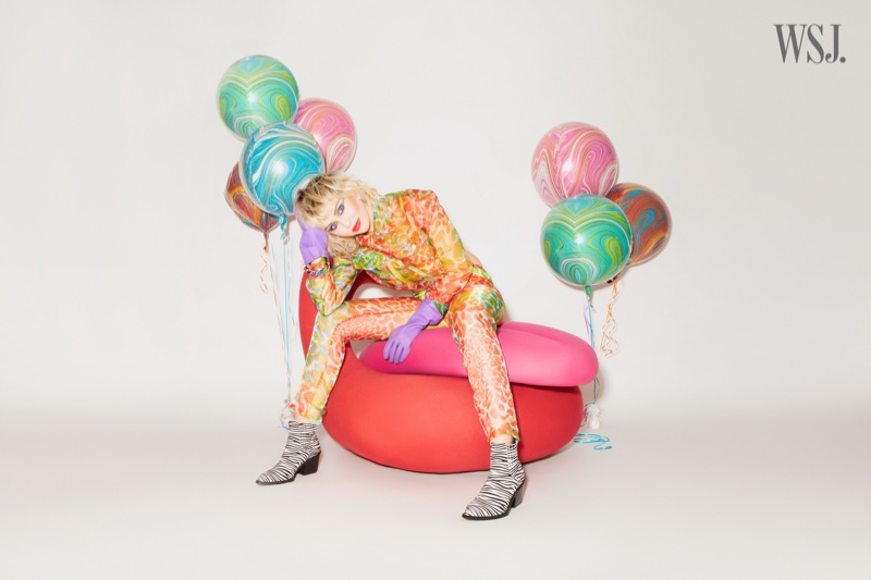 Sporting animal print, Miley Cyrus gets surrounded by balloons.