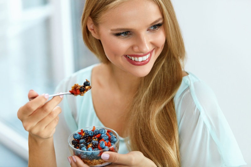 Smiling Blonde Model Eating Fruits