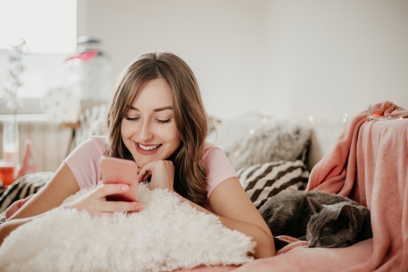 Smiling Woman Pink Phone Bedroom