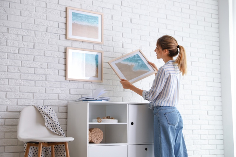 Woman Decorating Home Hanging Picture Frames