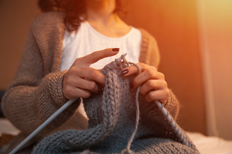 Woman Knitting Grey Needles