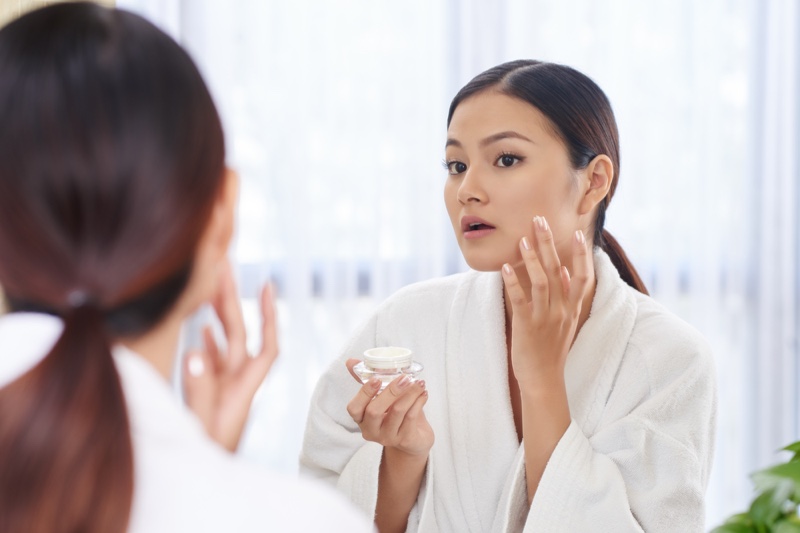 Asian Woman Applying Cream Skin Mirror