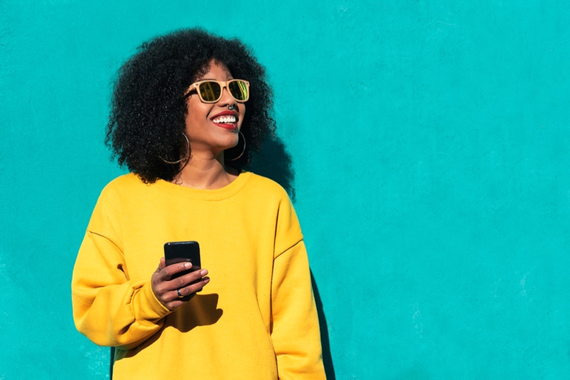 Smiling Black Woman Phone Afro Hair Yellow Sweater Sunglasses