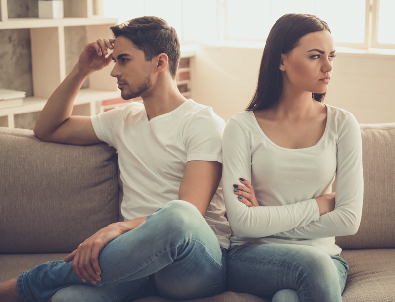 Unhappy Couple Arms Crossed Couch Jeans White Shirt