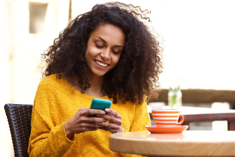 Black Woman Curly Hair Looking Phone