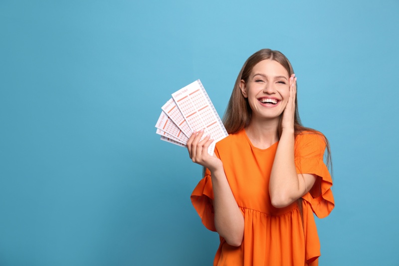 Smiling Woman Orange Top Bingo Lottery Tickets