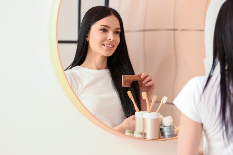 Woman Smiling Combing Hair Bathroom Mirror