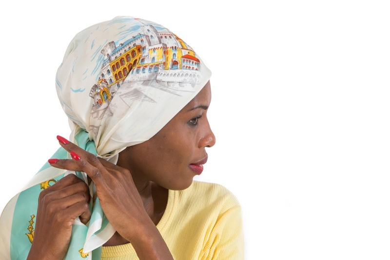 African Woman Tying Hair Scarf