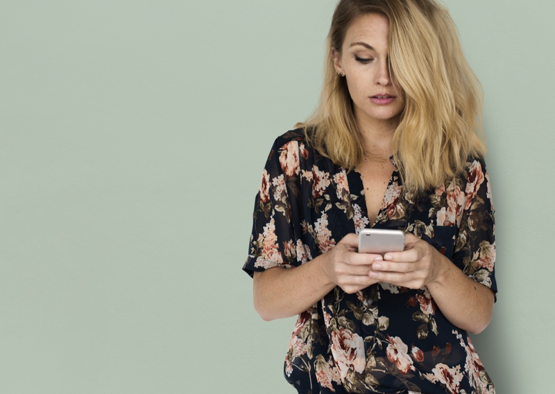 Blonde Woman Floral Print Shirt Holding Phone