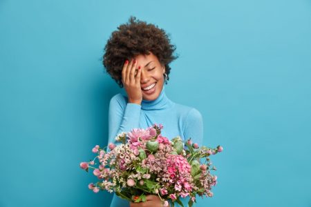 6 Online-Delivery Gifts to Absolutely Wow Her Smiling Afro Model Holding Bouquet Flowers Gift