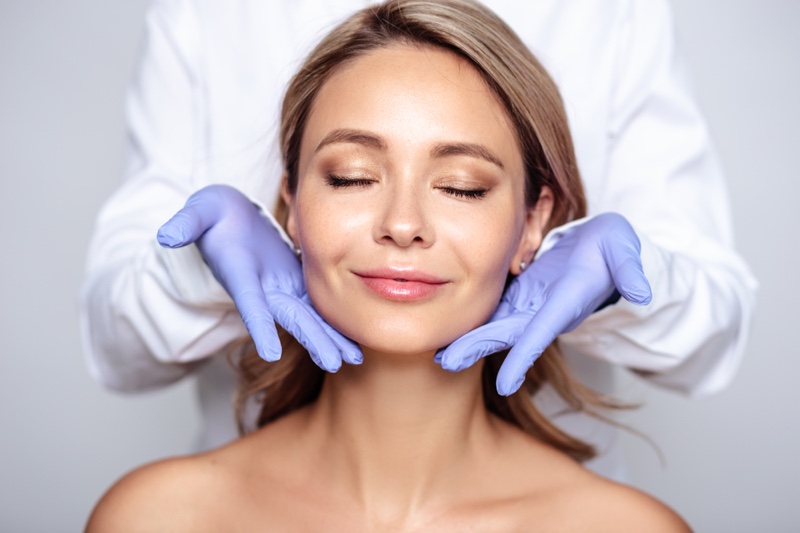 Smiling Woman Doctor's Hand Spa Surgery Face Concept