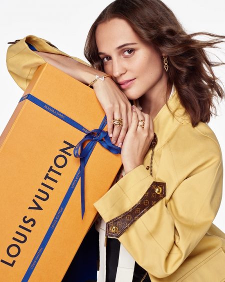 Alicia Vikander Dons Monogram Style for Louis Vuitton Holiday '20 Campaign Alicia Vikander poses with an oversized Louis Vuitton gift box for the brand's holiday 2020 campaign. The actress charms in a yellow Louis Vuitton coat, complete with leather monogram detailing.
