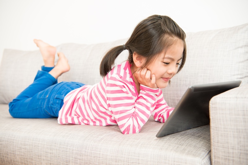 Asian Girl Viewing Tablet Couch