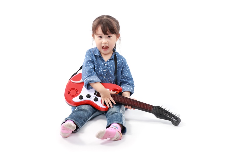 Little Asian Girl Playing Toy Guitar