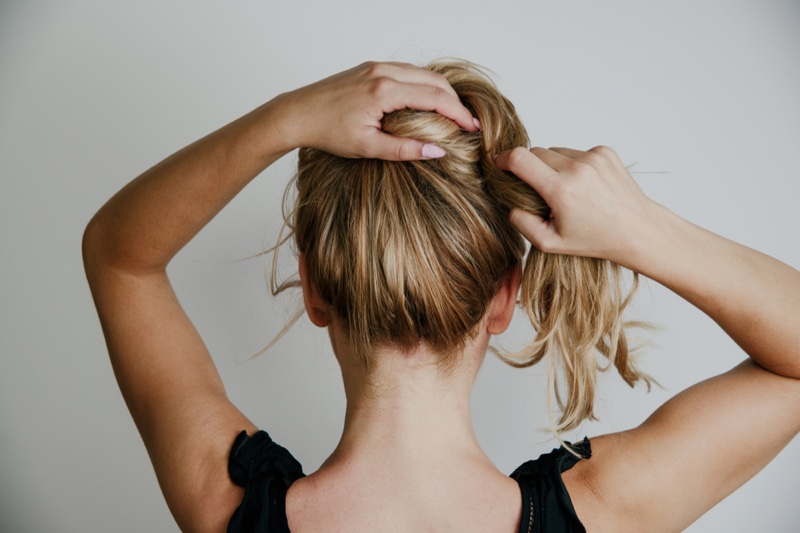 Woman Tying Up Blonde Hair