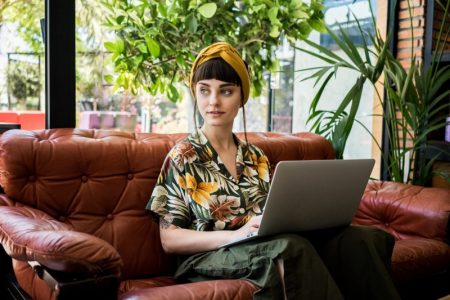 Different Types of Sofas for Studio Apartments Stylish Woman Sitting Leather Sofa Hawaiian Shirt Laptop