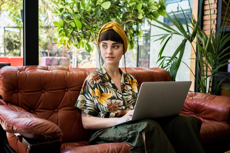 Stylish Woman Sitting Leather Sofa Hawaiian Shirt Laptop