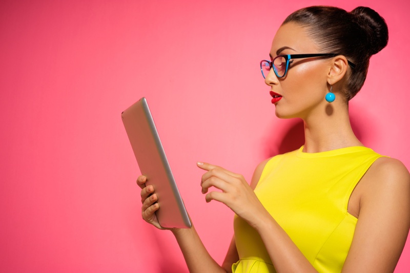 Stylish Woman Yellow Top Viewing Tablet