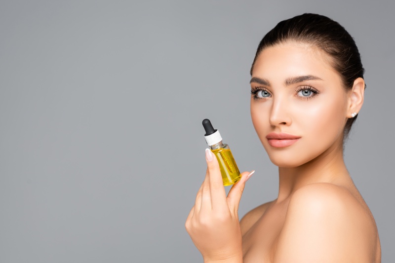 Beauty Model Holding Oil Bottle