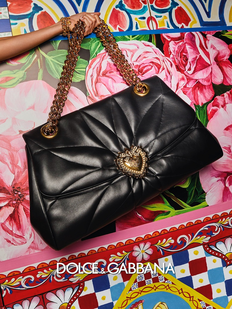 Dolce & Gabbana features a gold heart embellishment on a handbag in its spring-summer 2021 campaign.