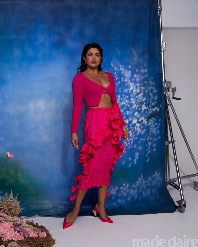 Taking a stand, Priyanka Chopra poses in Versace look, Dolce & Gabbana earrings, and Christian Louboutin shoes.