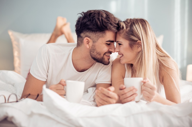 Smiling Couple Bed Cups Relaxed