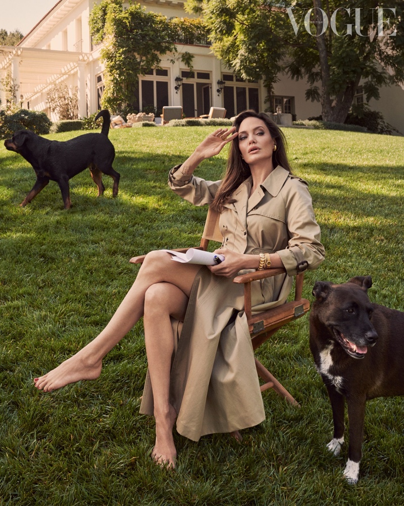 Posing with her dogs Dusty and Sophia, Angelina Jolie wears a Dior trench coat.