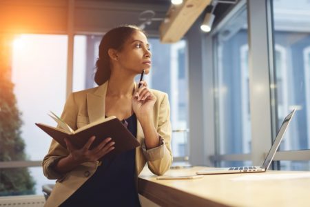 Stylish Pen Brands for Distinguished Women Black Woman Holding Pen Book Thoughtful Desk