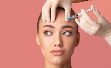 Can You Prolong the Life of Your Fillers and Botox? Botox Forehead Needle Closeup Attractive Woman Gloved Hands