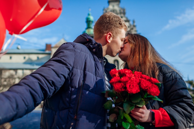 Couple Kissing Woman Holding Bouquet Roses red