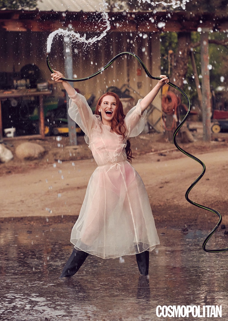 Posing with a hose, Madelaine Petsch wears a pink Sandy Liang dress and bralette with La Chameau boots.