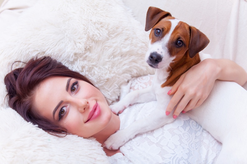 Model Smiling Holding Dog Laying Down