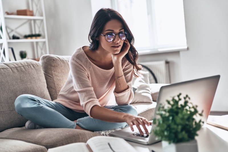 Sitting Couch Woman Viewing Laptop Pink Sweater