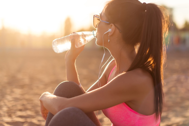 Woman Drinking Water Bottle Sitting