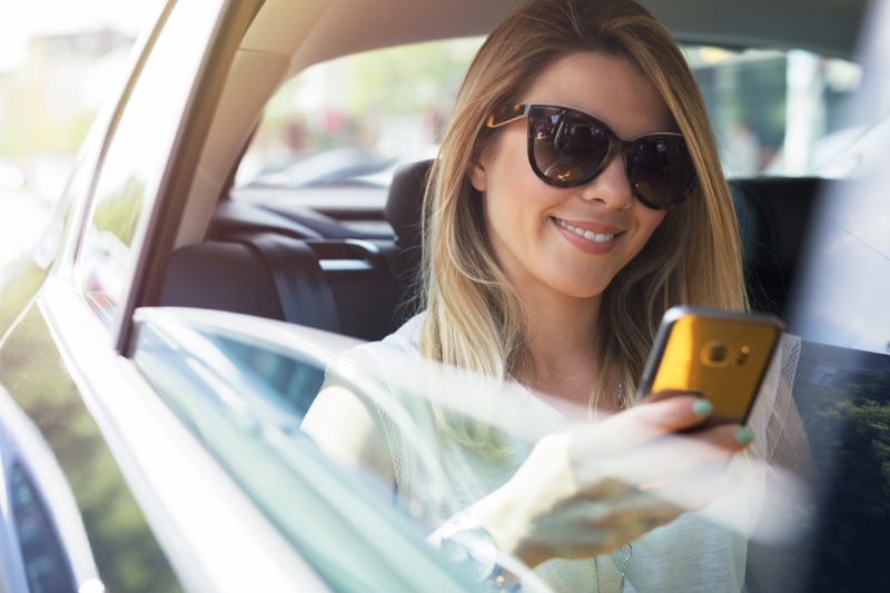 Smiling Woman Holding Phone Car Sunglasses