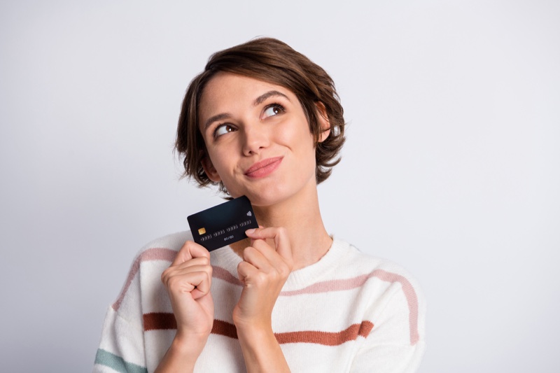 Smiling Woman Thinking Holding Credit Card