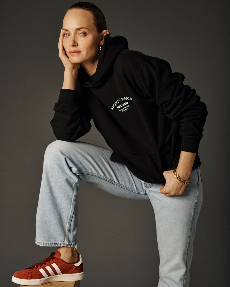 Wearing a hoodie, Amber Valletta poses in Sporty & Rich spring 2021 campaign.