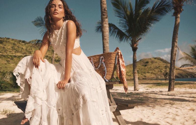 Andreea Diaconu poses in white beach dress for Zimmermann Swim summer 2021 campaign.