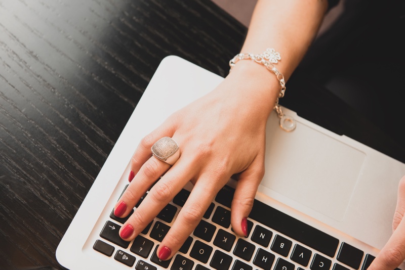 Closeup Woman's Hand Ring Bracelet Using Laptop