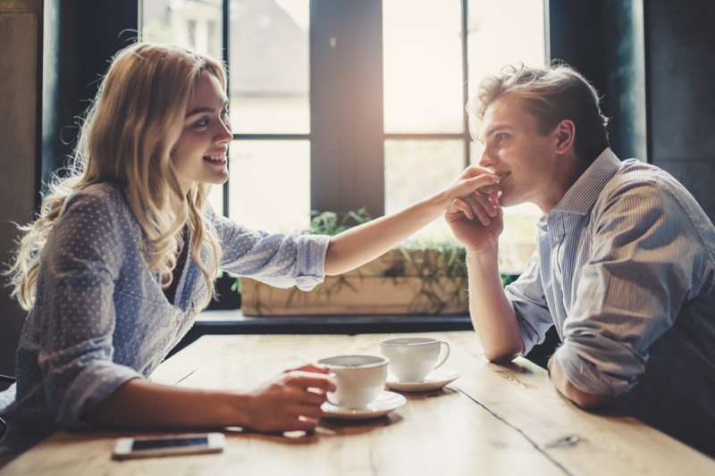 Smiling Couple Cafe Table Holding Hands