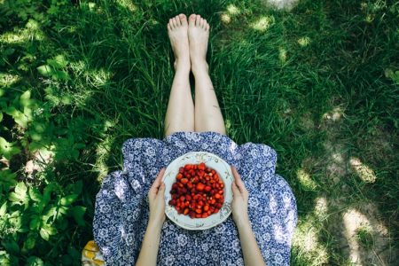 5 Unexpected Ways Berries Help Your Health Woman Bowl of Strawberries Legs Grass