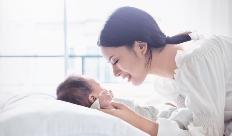 Asian Mother Smiling Baby