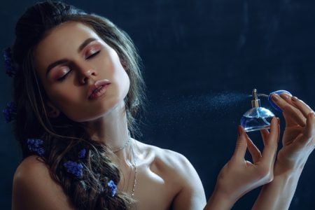 Beauty Model Spraying Perfume Blue Bottle