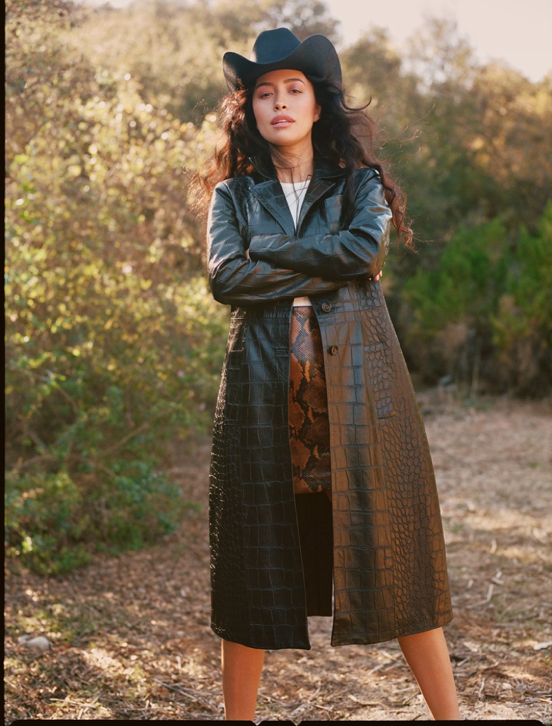 Actress Christian Serratos wears a cowgirl hat and leather coat.