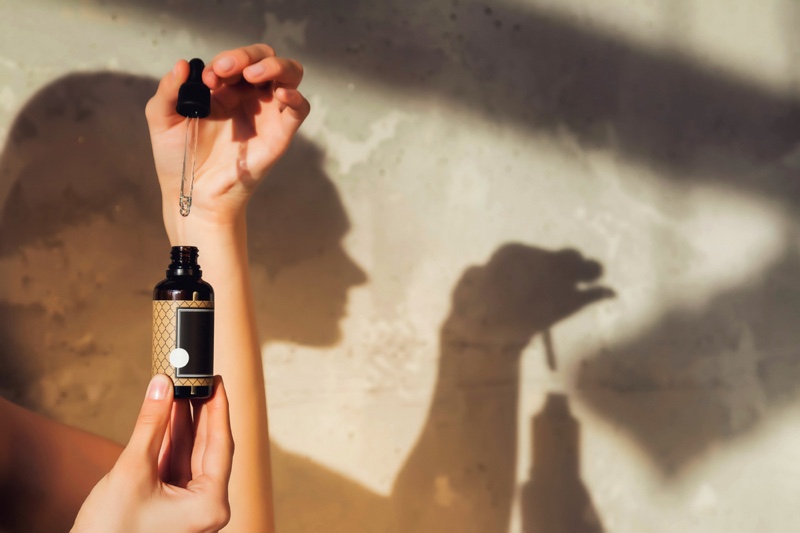 Woman Holding Oil Bottle Dropper