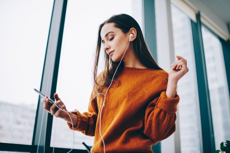 Woman Listening Music Podcast Earphones Orange Sweater