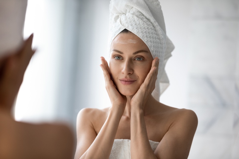 Woman Skincare Touching Face Towel Covering Hair