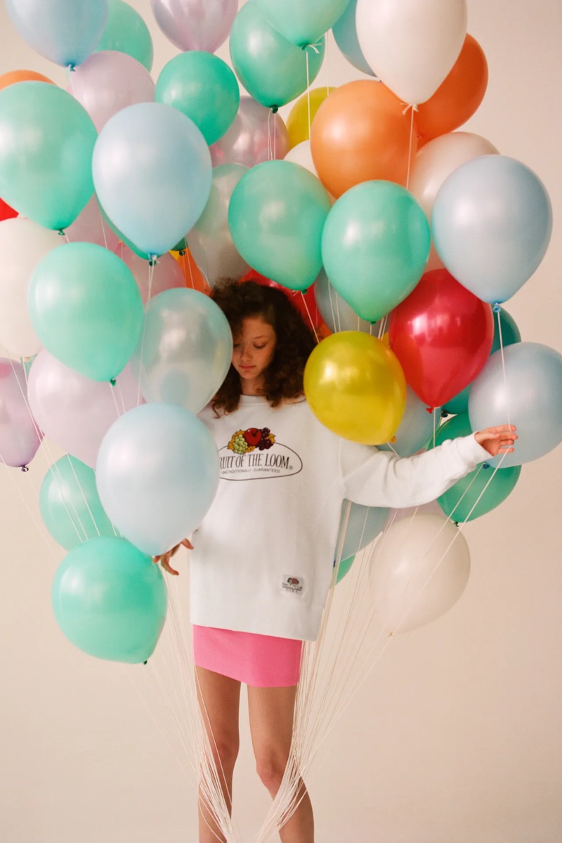 Posing with balloons, Sara Grace Wallerstedt models Zara x Fruit of the Loom collaboration.