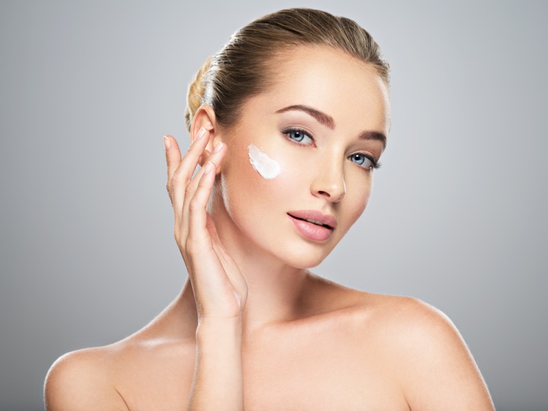 Beauty Model Applying Face Cream