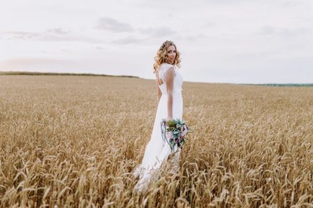 Bride Outdoors Long Wedding Dress Holding Flowers Wheat Field